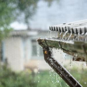 Rain flows off a roof
