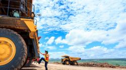 Two women work with an enormous tractor