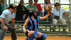 A catcher in full armour takes a catch