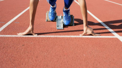 Sprinter at a starting block, ready to run. 